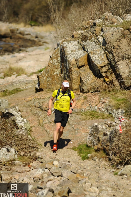 a man that is walking down some rocks