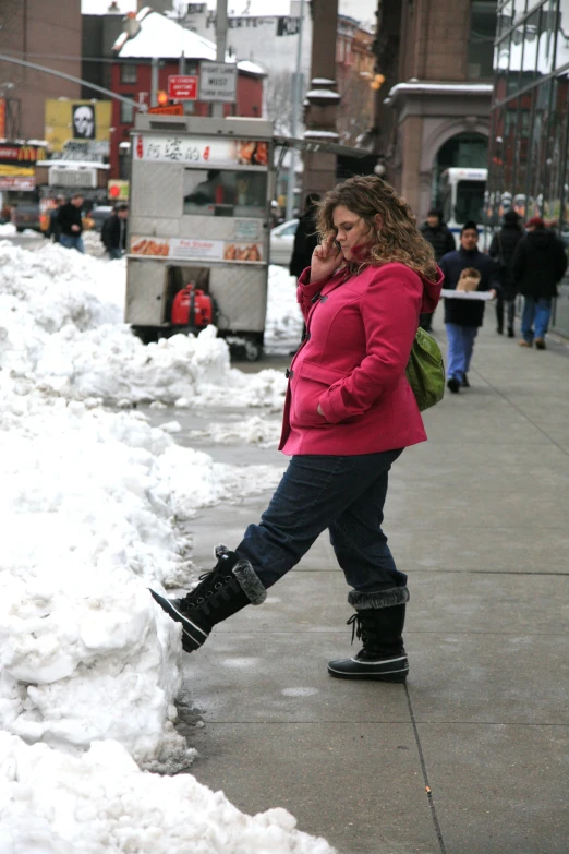 a woman on a street with snow all around her