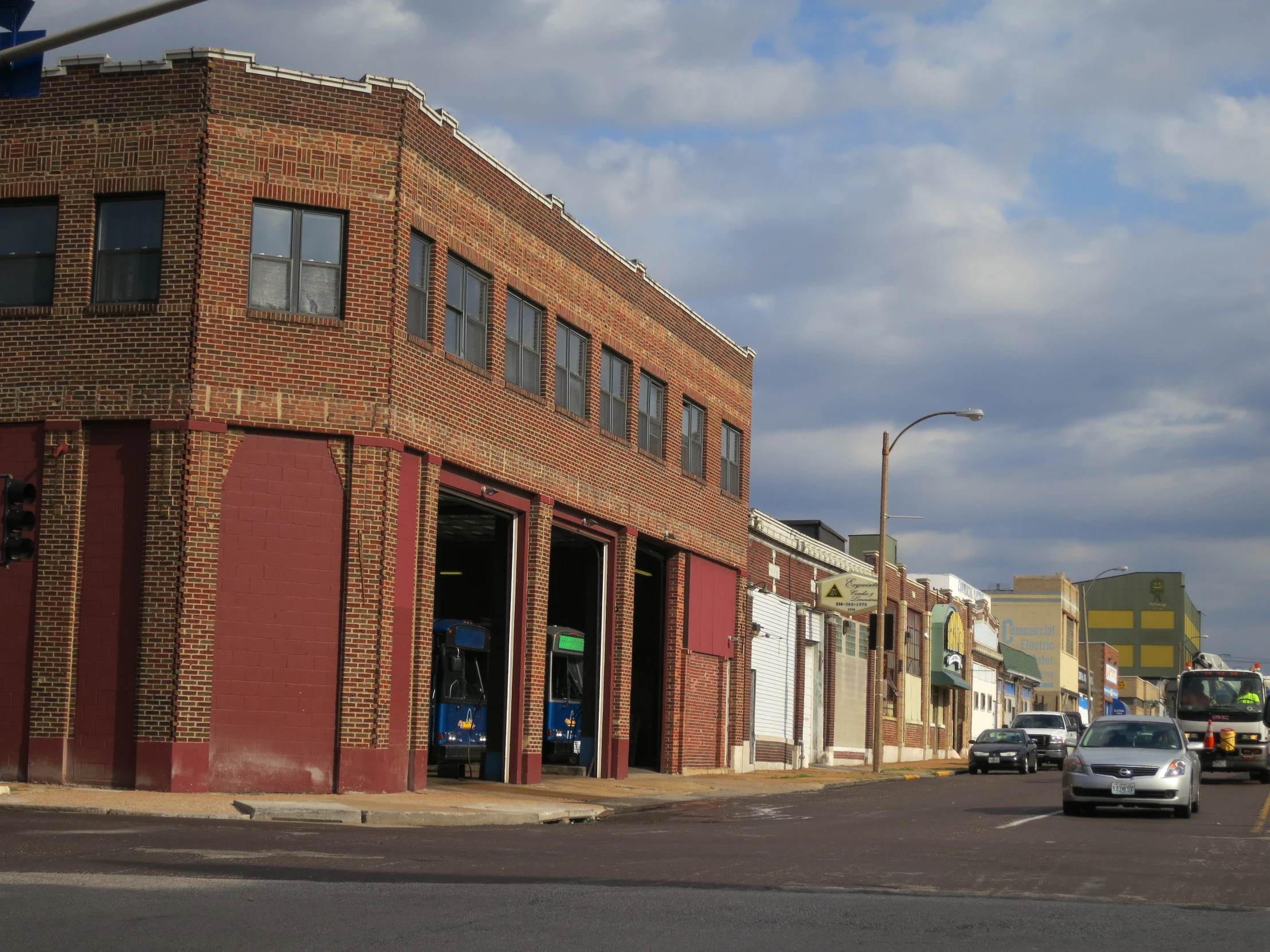 cars are driving in front of a brick building