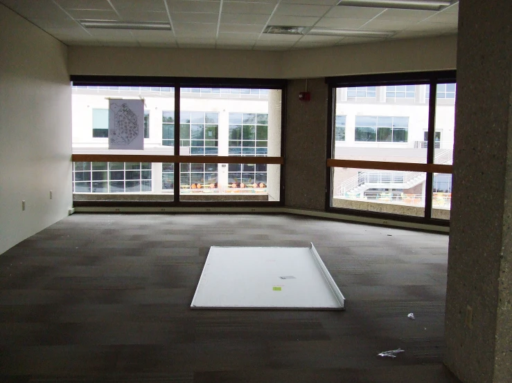 an empty room has windows that look out onto a parking lot