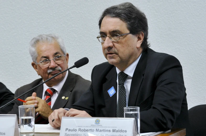 a couple of men sitting in front of microphones