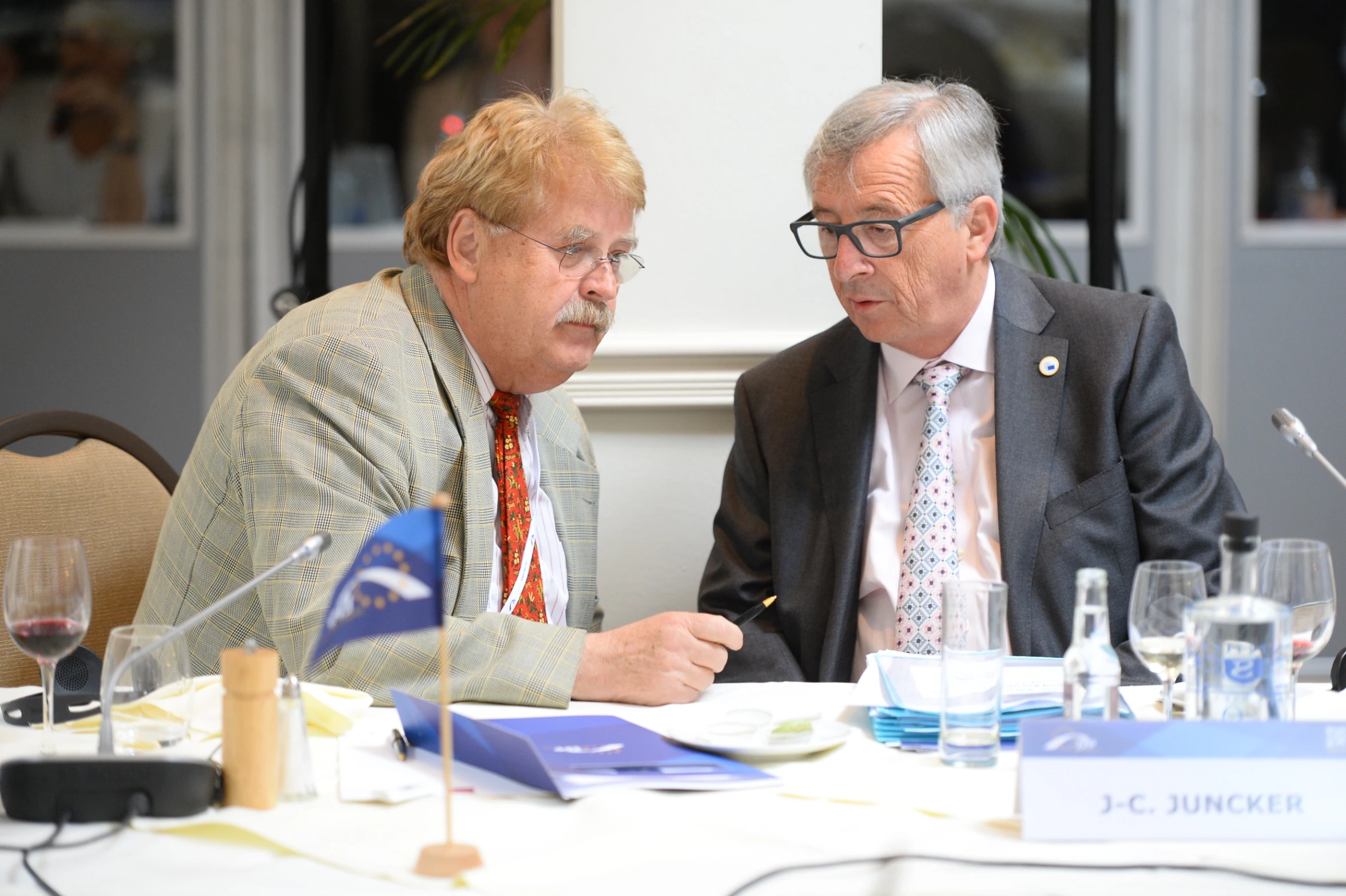 two men sitting at a table and talking