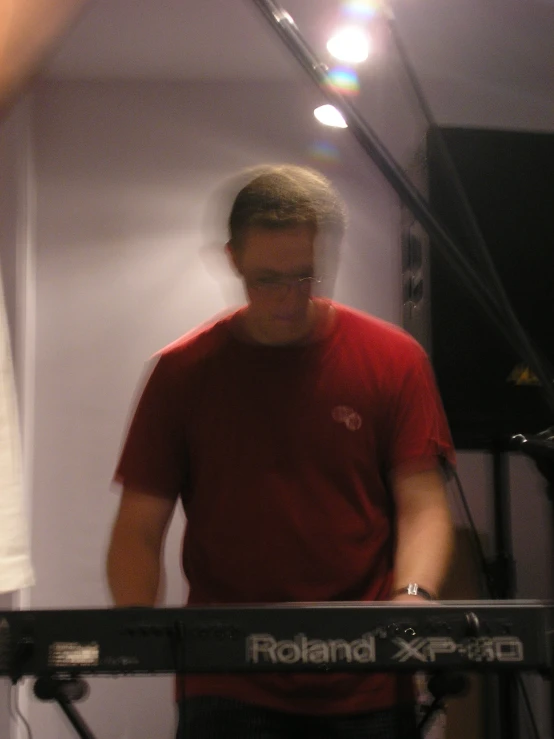 a man is playing the keyboard in a recording studio