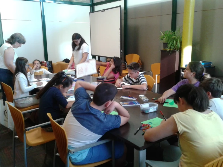 a group of people sitting around a table working together