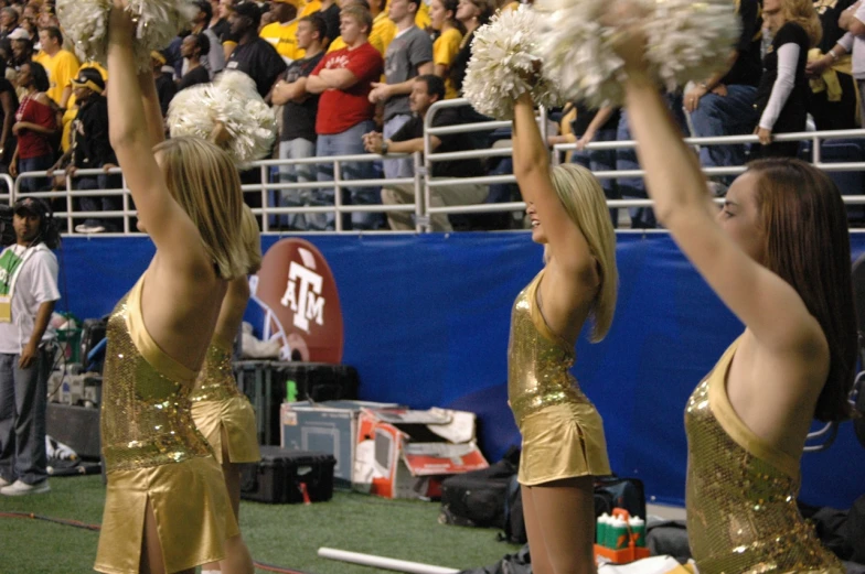 some young women in gold dresses are holding white flowers