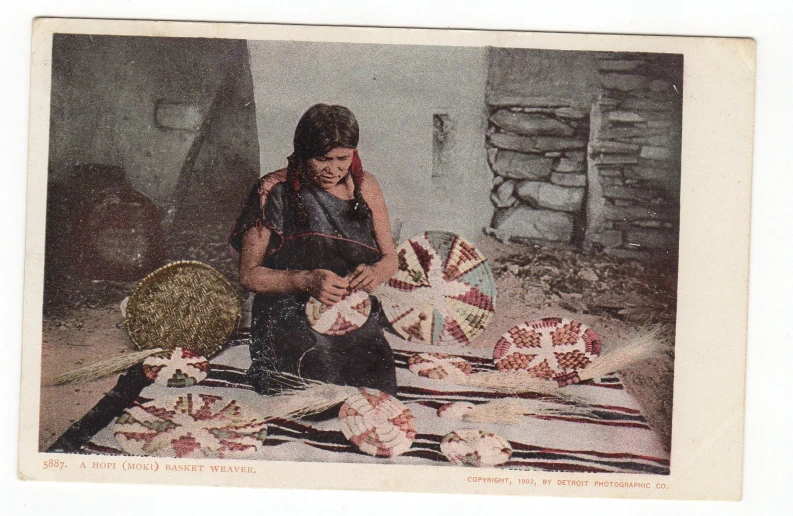 a woman sitting on top of a blanket next to a bunch of ribbons