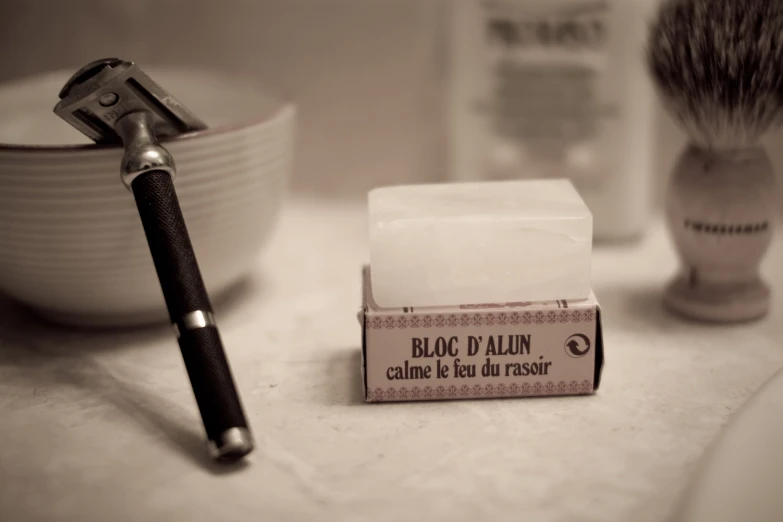 a shaving brush next to an unused razor