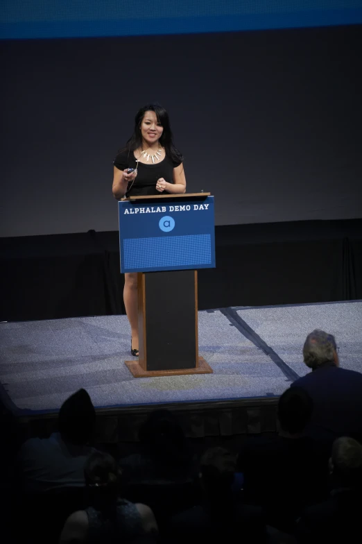 a woman is giving a speech on stage