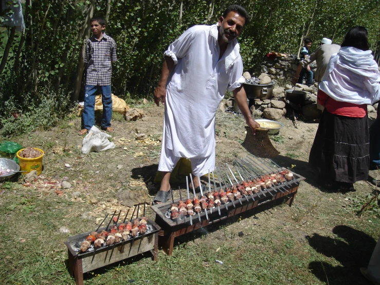 several people doing soing to cook in the grass