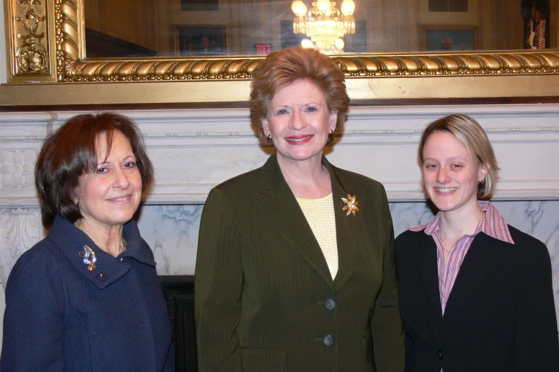 two women and a woman in black jacket smiling at the camera