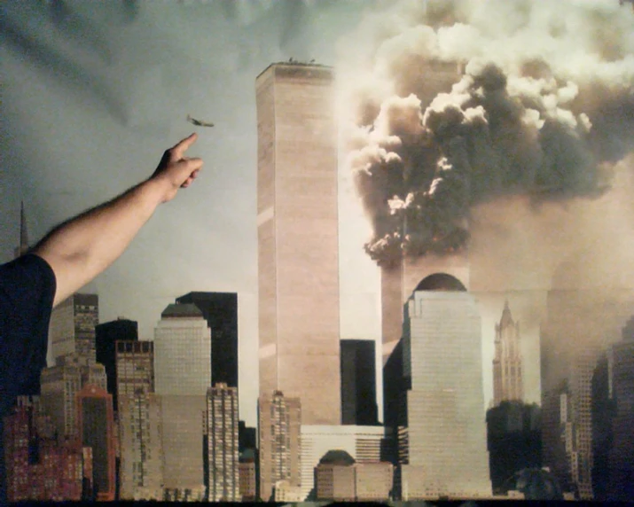 a person is pointing to the twin towers that are in the air