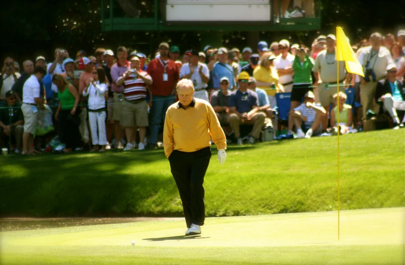 a man walking on a golf course towards the green