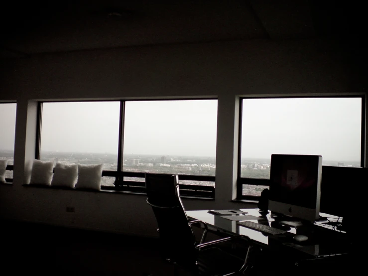 two windows in the middle of an office with a chair next to it