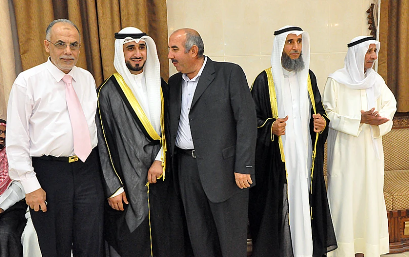 five men stand with two women in formal clothing