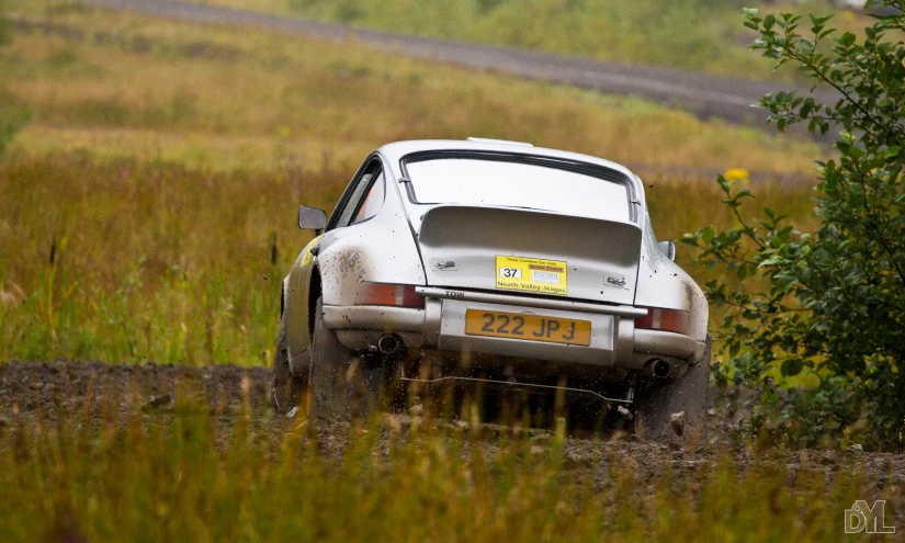 an old car is driving through a field