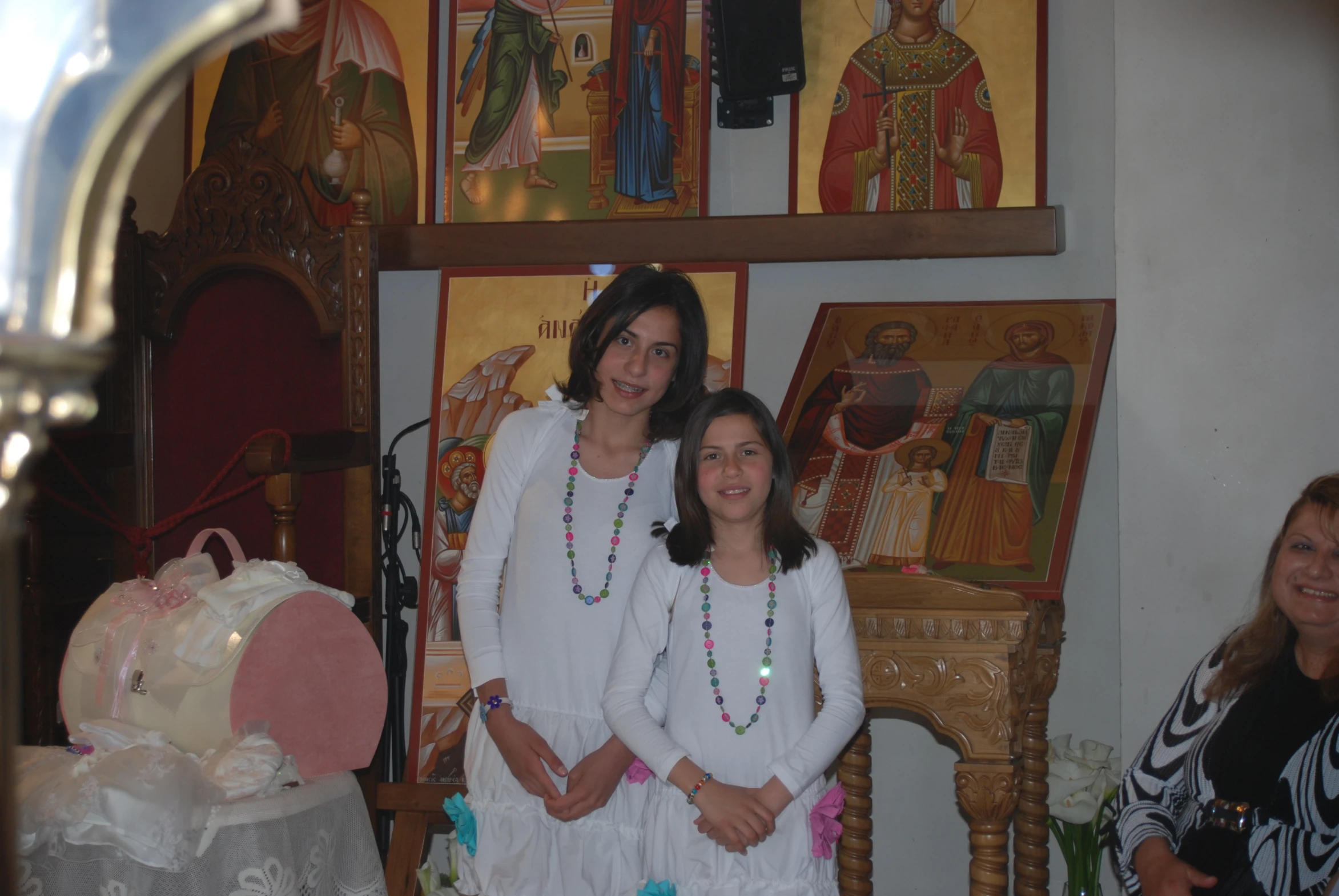 two women pose for the camera in front of pictures of men