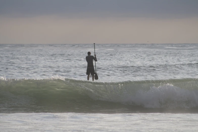 a person stands on surf board in front of the water