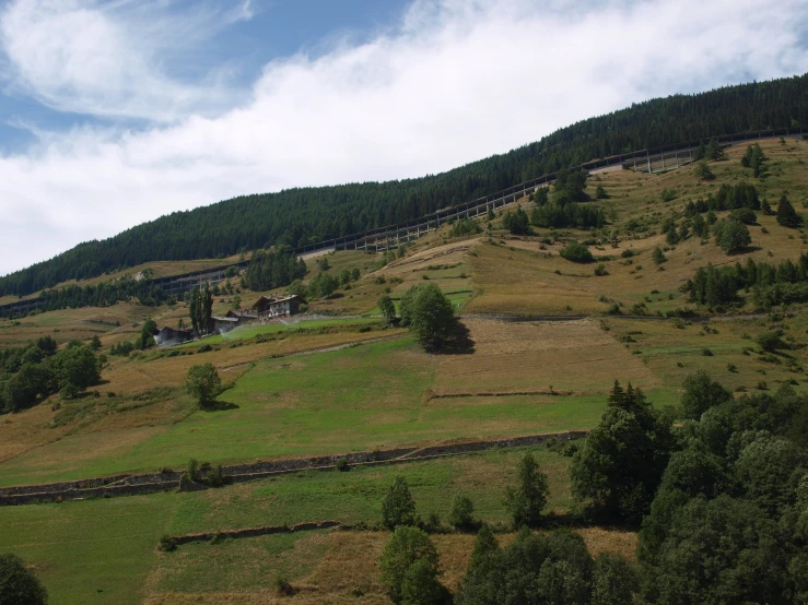 the view from atop of the hill shows trees and grass