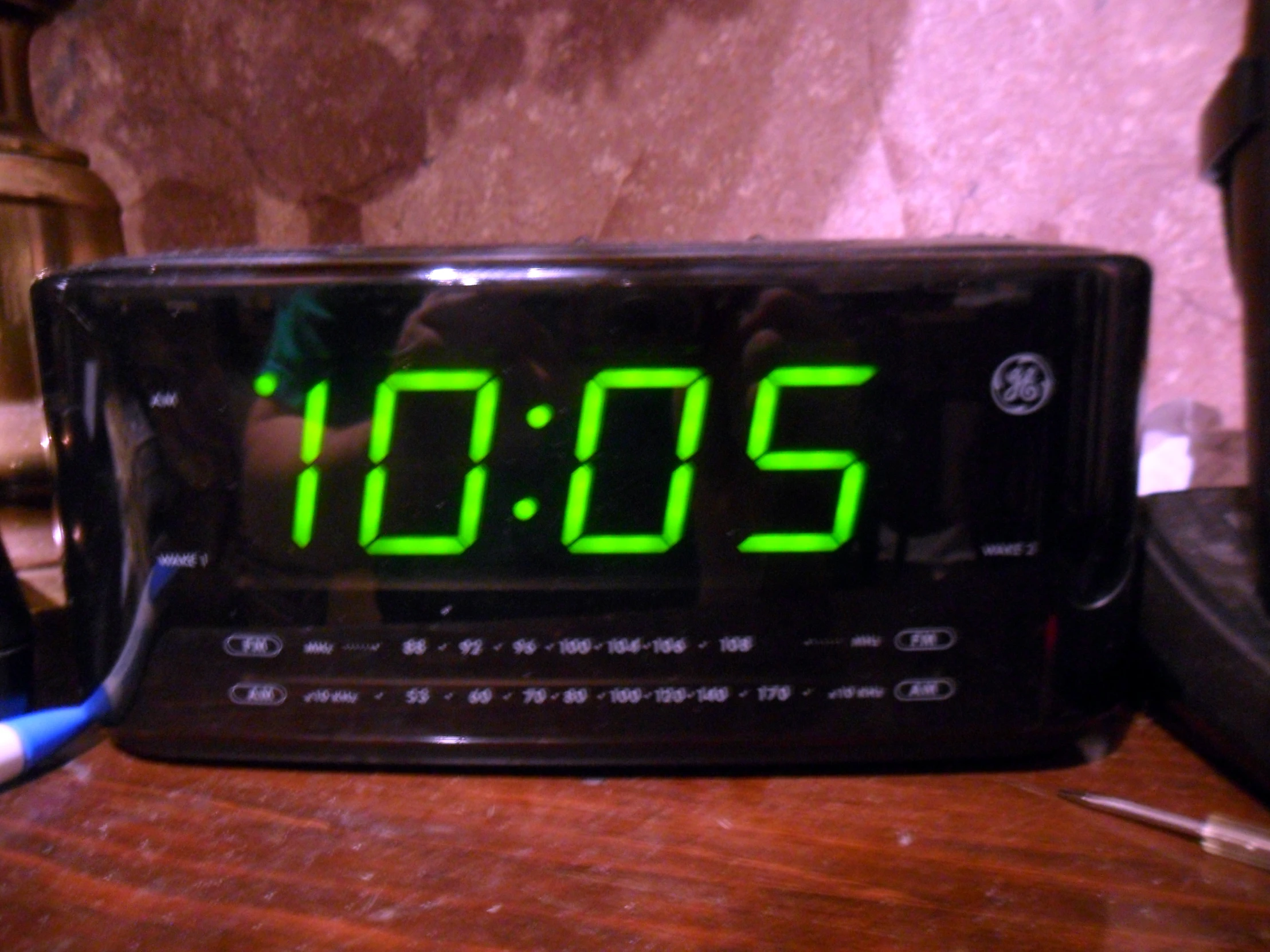 an alarm clock sitting on top of a wooden table