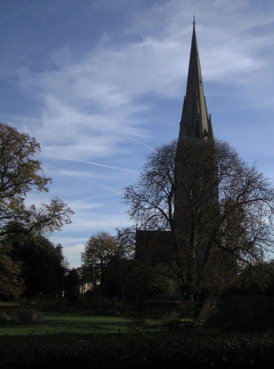 an old church steeple is seen near some trees