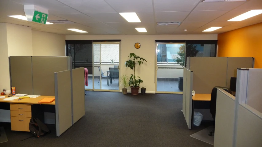 an office cubicle with doors open and cubicles around it