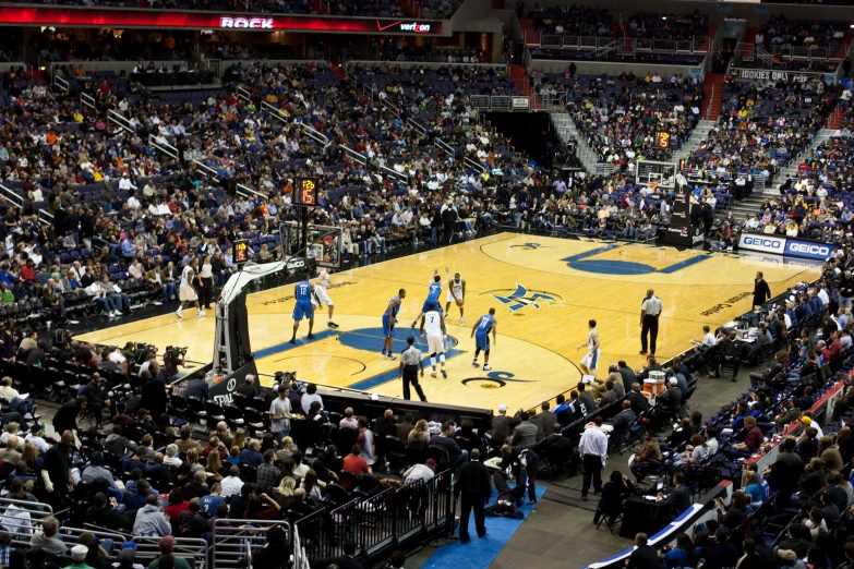 a crowded basketball court with people watching