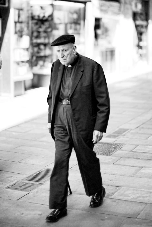 man in black suit and cap with cane walking