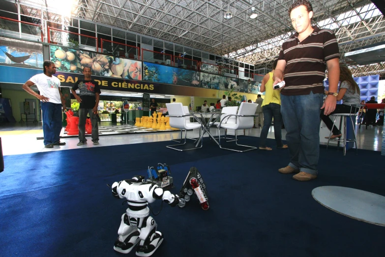 two men stand next to a robot toy