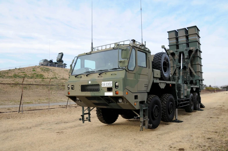 some military trucks parked together in a dirt field