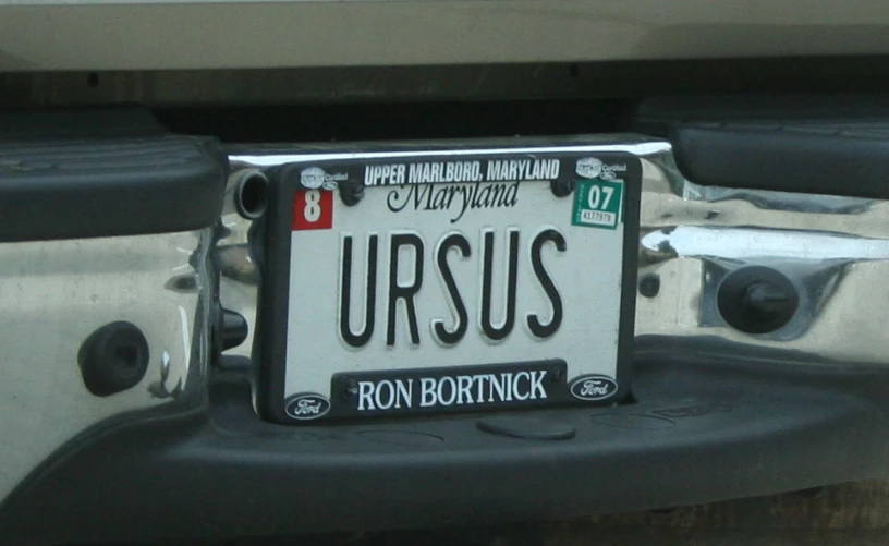 a plate is seen hanging on the bumper of a vehicle