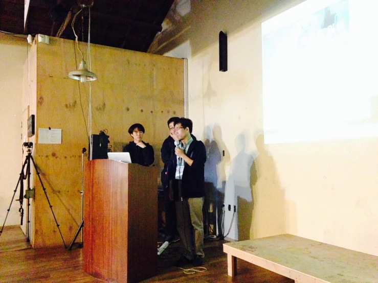 two people at a podium behind wooden boards