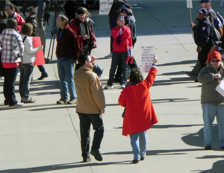 a crowd of people standing around each other near street signs