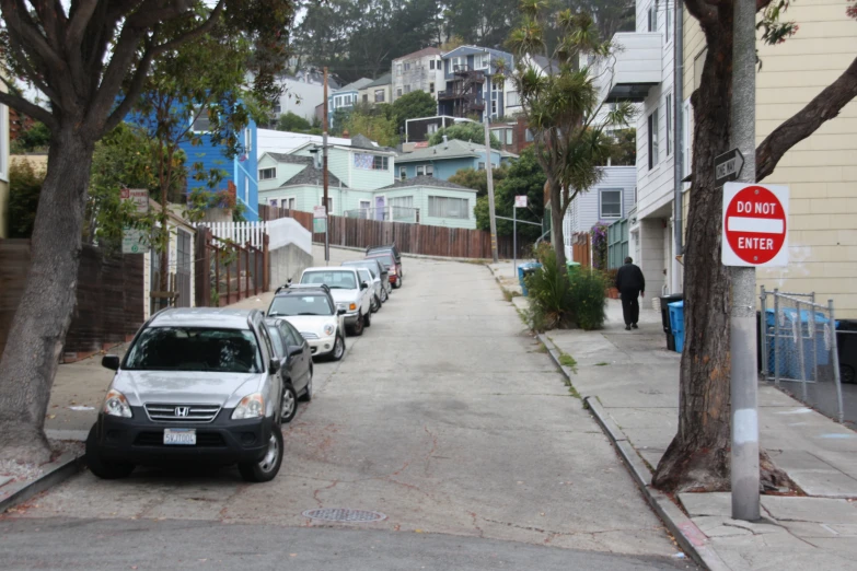 a street has cars parked along a long narrow road