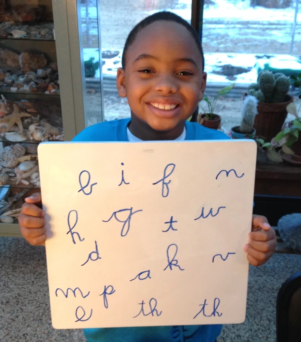 a child holding up a piece of paper with writing on it