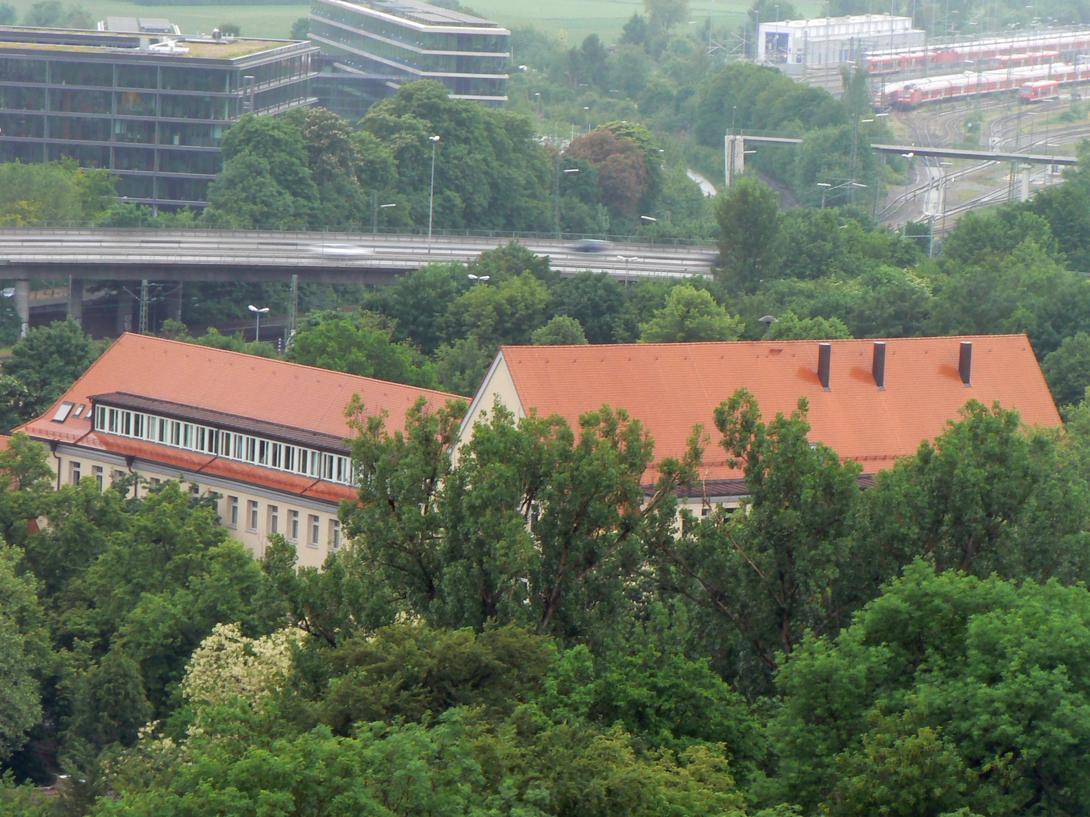 a large building surrounded by trees next to a river