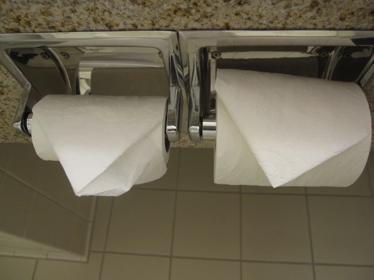 two white towels are hanging from the wall of the bathroom