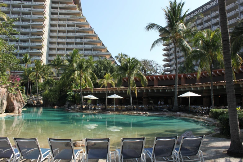 several lawn chairs surrounding a small pool