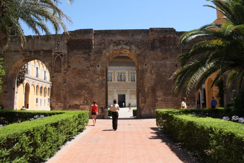 the people are walking through the archways to their destination