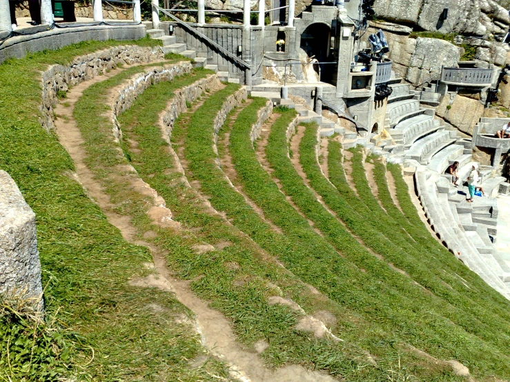 an amphit with a stone wall, a field and many steps leading to the main entrance