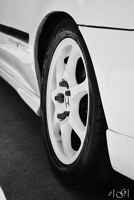close up view of a white car tire with one wheel missing