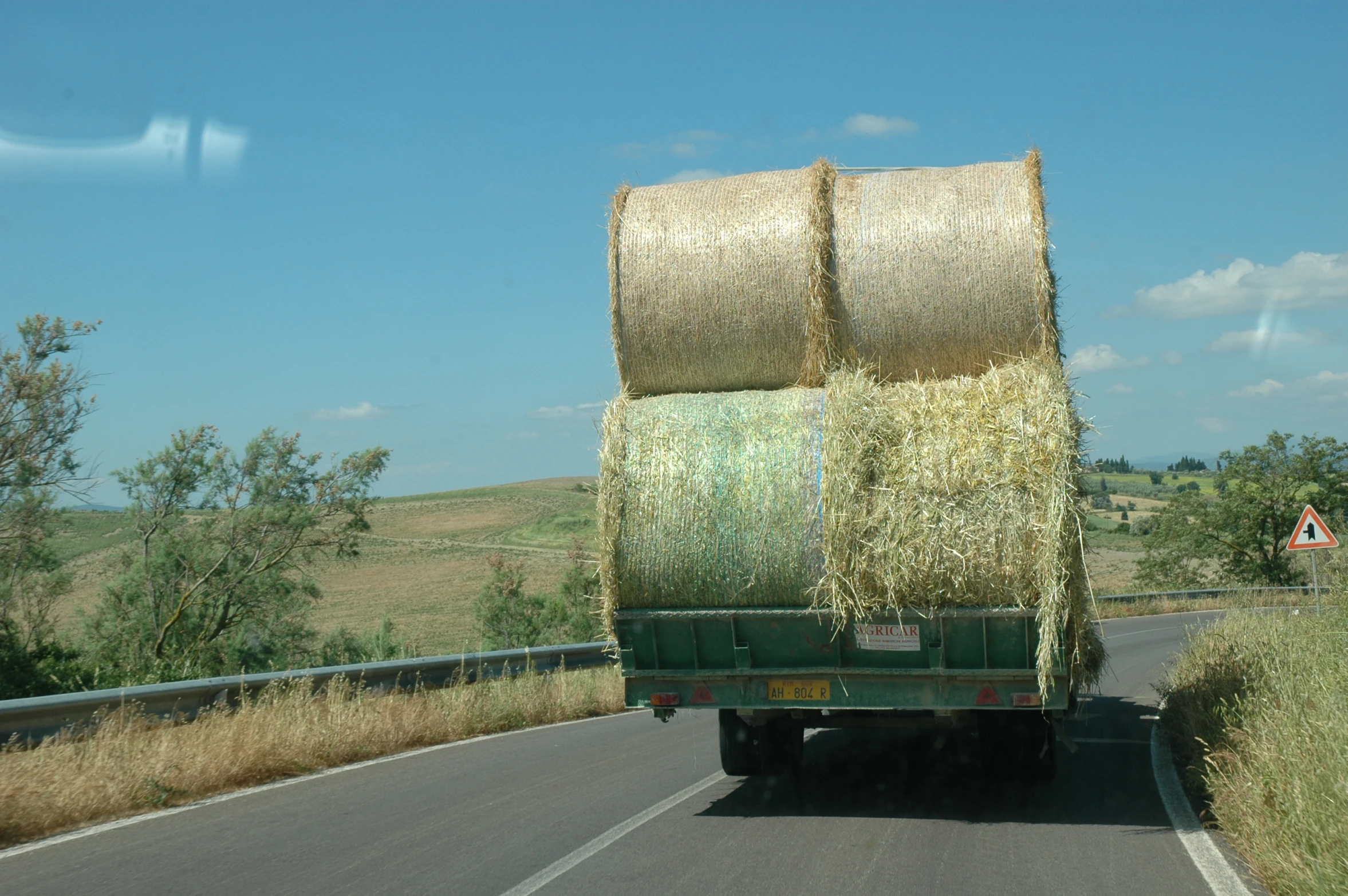 green truck with hay bales on the back