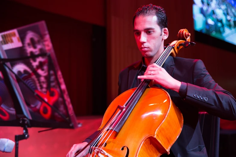 a male cellphoneer playing a musical instrument in an auditorium