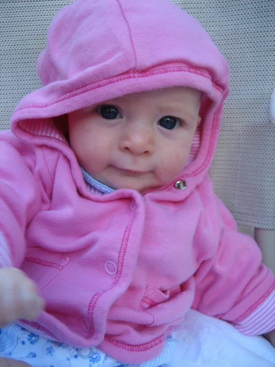 the baby is smiling in her pink outfit