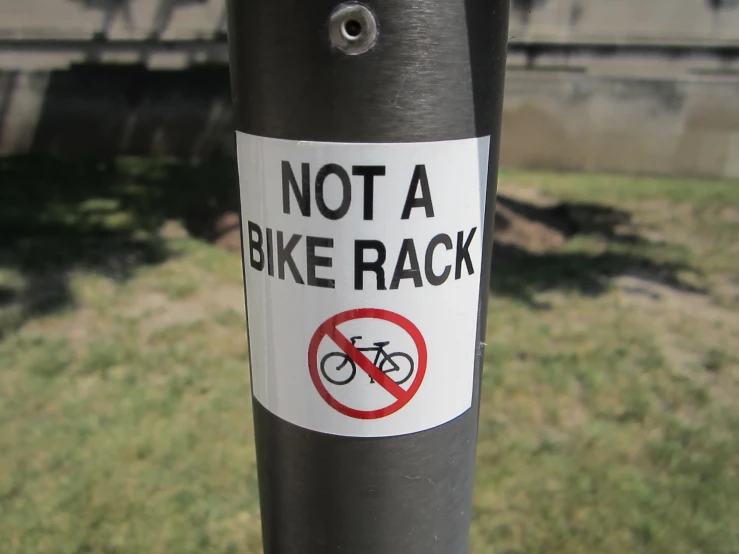 a close up of a sign on a pole near a building