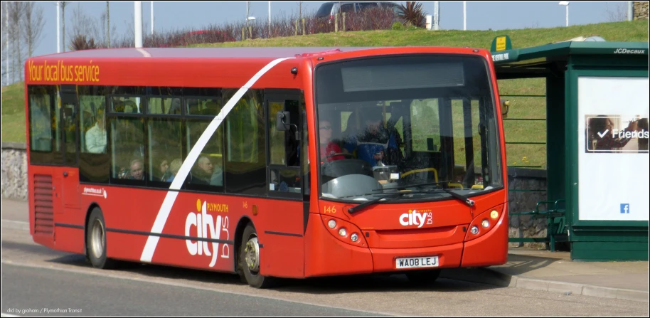 a red city bus drives through town