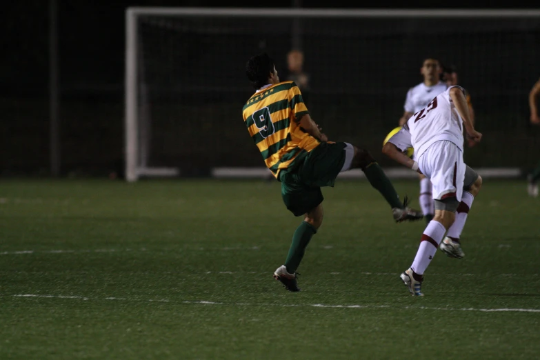 two men kicking a soccer ball in a field