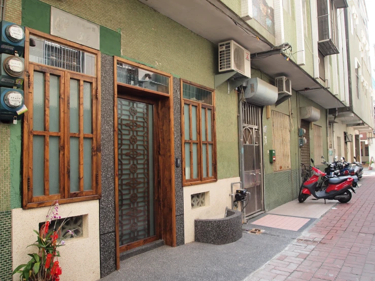 a scooter parked outside a small green building