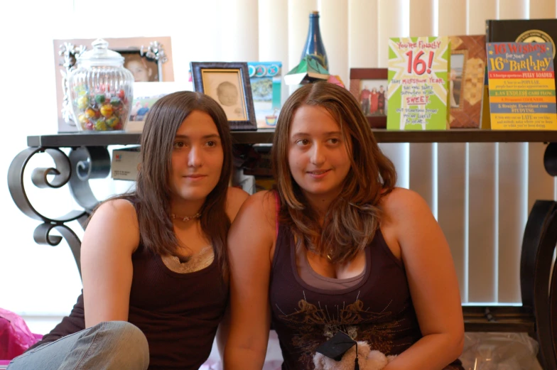 two young women pose for the camera with their stuffed toys