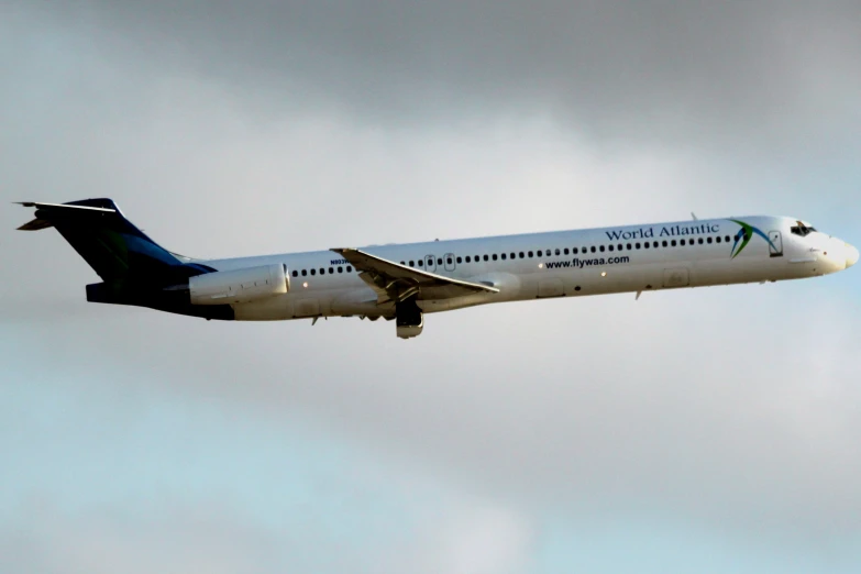 a white and blue airplane in a cloudy sky