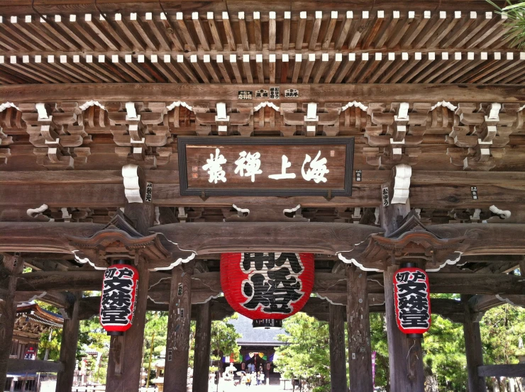 an oriental type of shrine with a red and white lantern hanging from it's ceiling